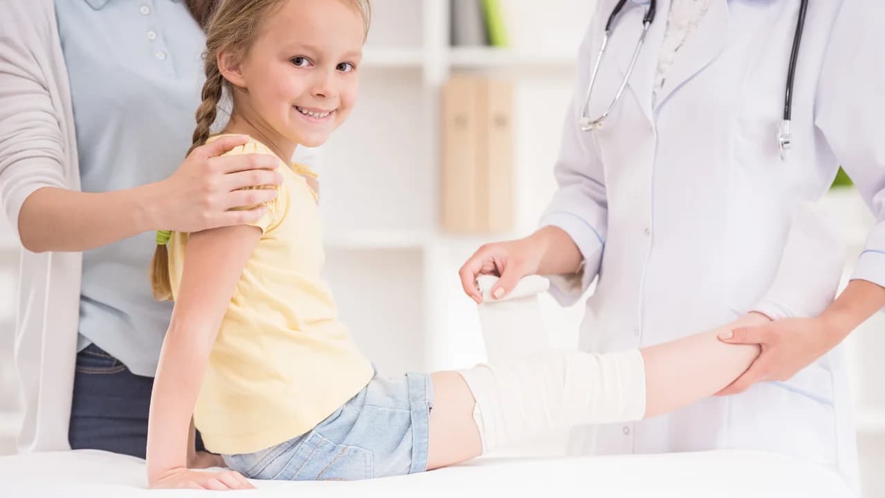 A doctor checking a smiling girl's arm