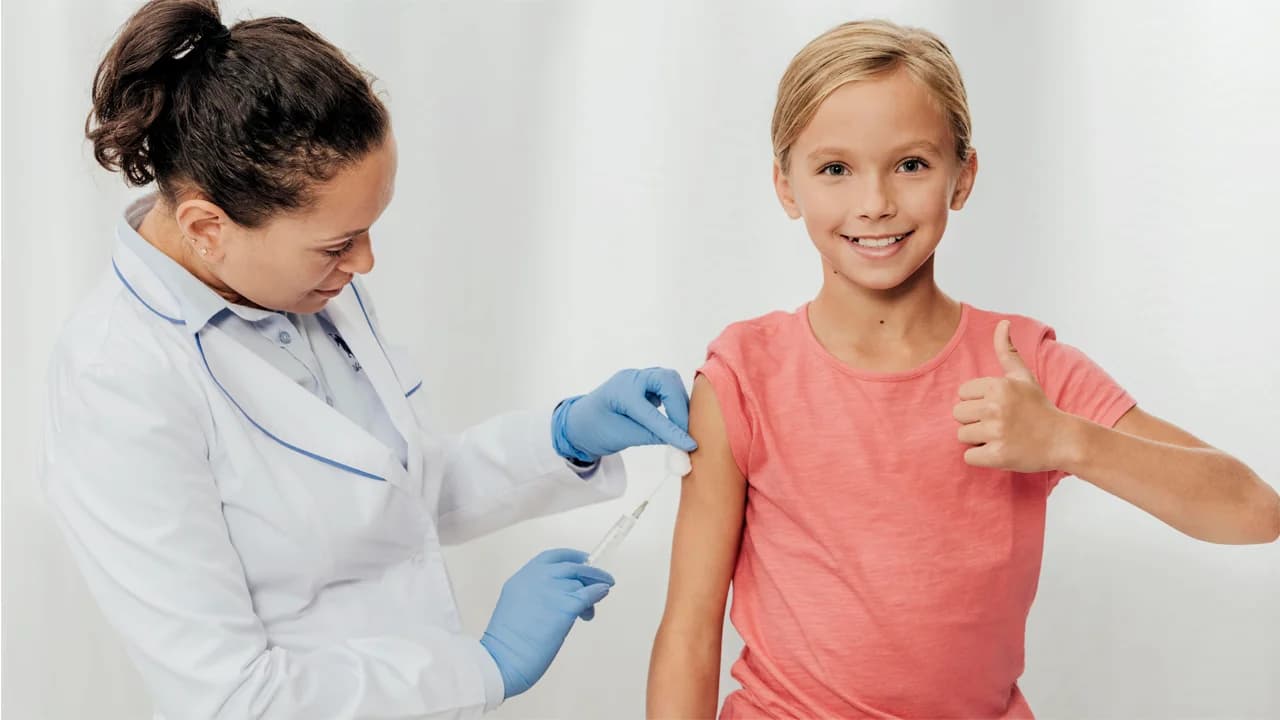 A nurse giving a smiling child a vaccination