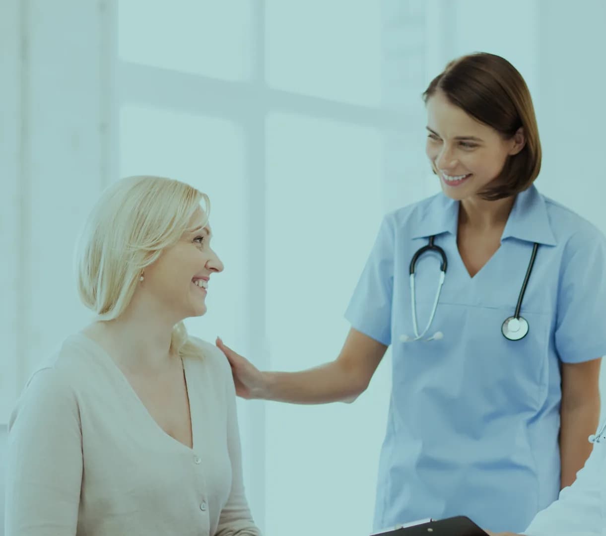 A clinician reassuring a patient with a hand on her shoulder