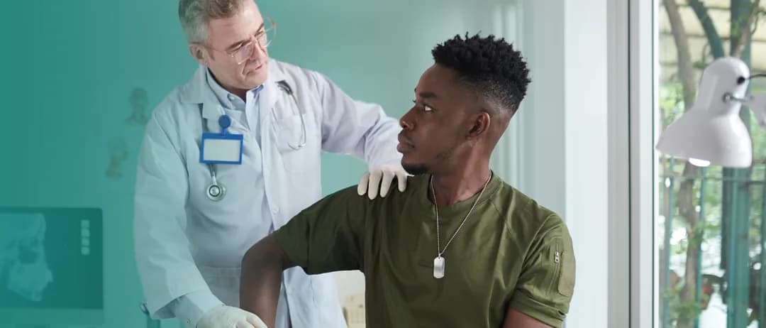 A doctor reassures a patient with a hand on his shoulder