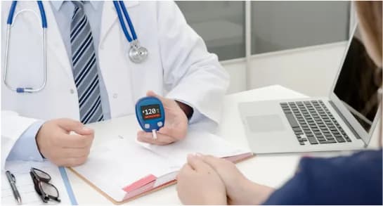 A doctor holding a blood glucose meter