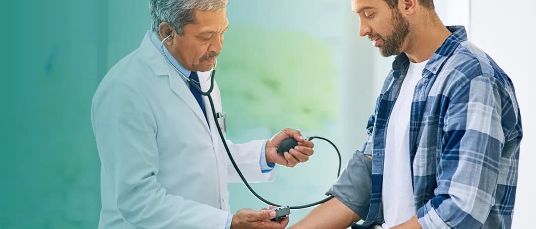 A doctor checks a man’s blood pressure