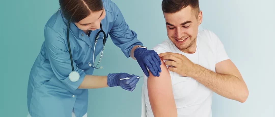 A nurse gives a man a vaccination in his upper arm