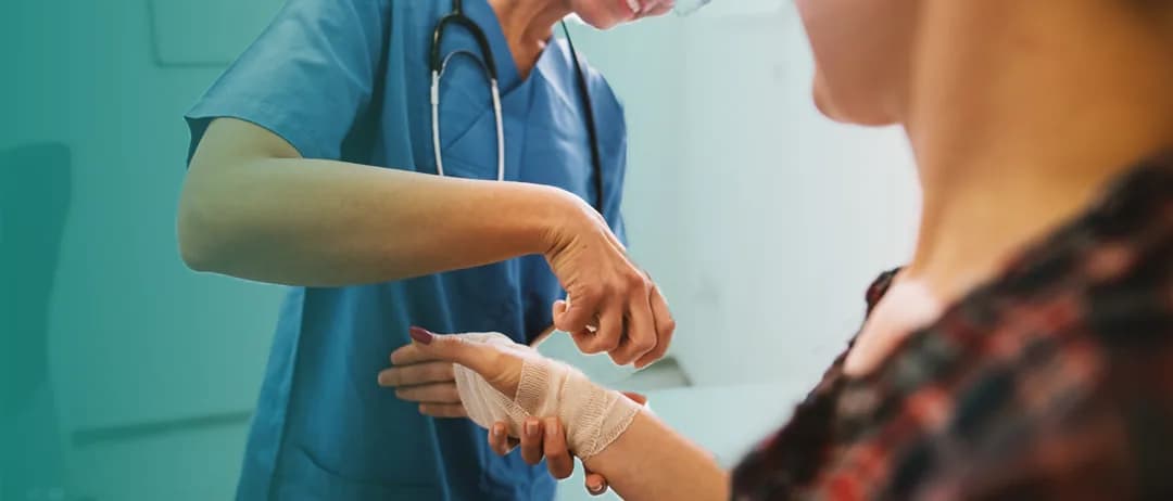 A clinician dresses a wound on a patient’s arm