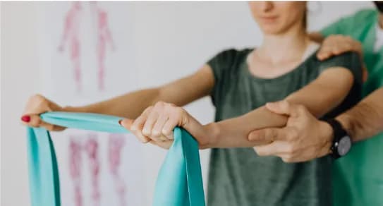 A physiotherapist guides a patient through a resistance-band exercise